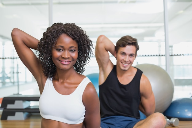 Fit couple warming up on exercise mats