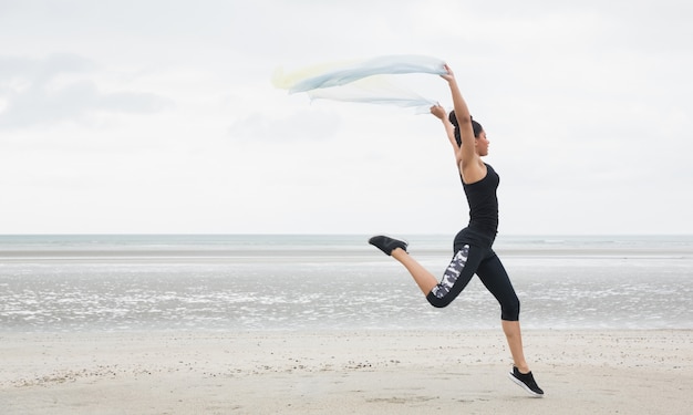 Fit girl leaping with scarf 