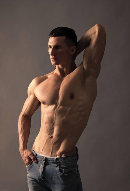 Fit guy with six pack abs torso pose shirtless grey background muscle