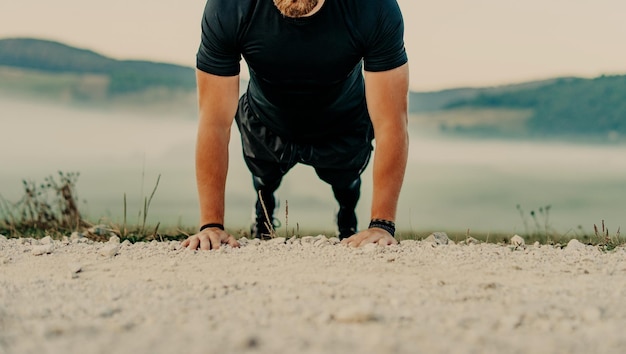 Fit man doing push ups exercise at outdoor gym. Core body workout athlete planking or doing pushup on grass.