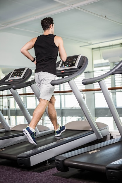 Fit man running on treadmill at the gym