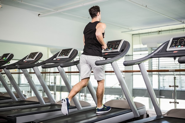 Fit man running on treadmill at the gym