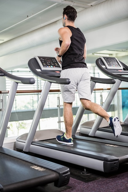 Fit man running on treadmill at the gym