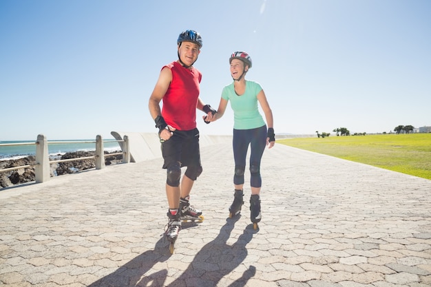 Fit mature couple rollerblading on the pier 