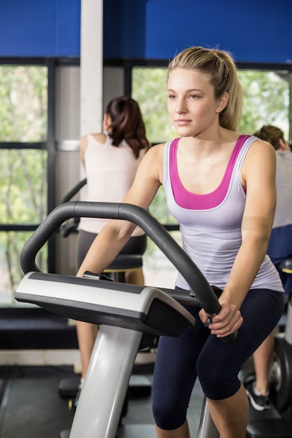 Fit woman doing exercise bike at gym