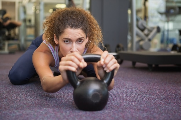 Photo fit woman lying with kettlebell