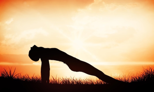 Fit woman stretching body in the fitness studio against orange sunrise