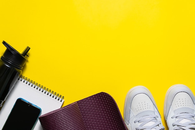 Fitness accessories on bright yellow background.