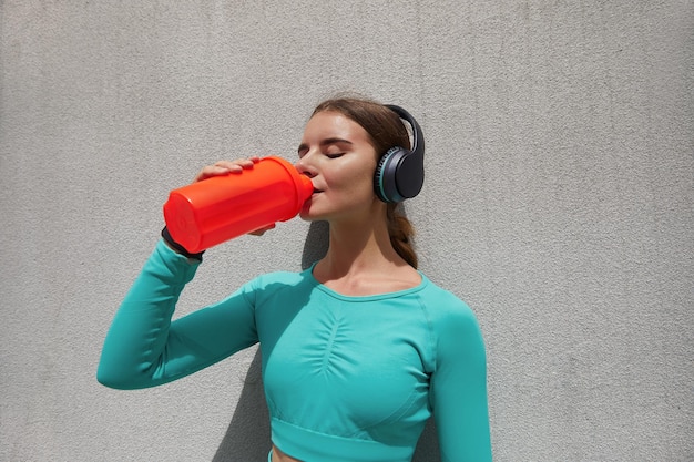 fitness athlete woman drinking water after work out exercising Woman drinking water from bottle