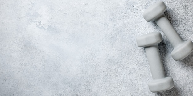 Fitness concept with dumbbells set on stone surface