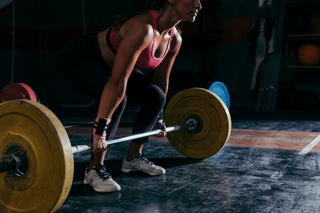 Fitness concept with woman working out with barbell