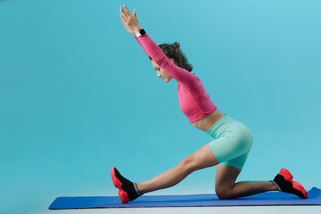 Fitness and diet concept Young woman with athletic body and perfect buttocks is lying on her back doing exercises