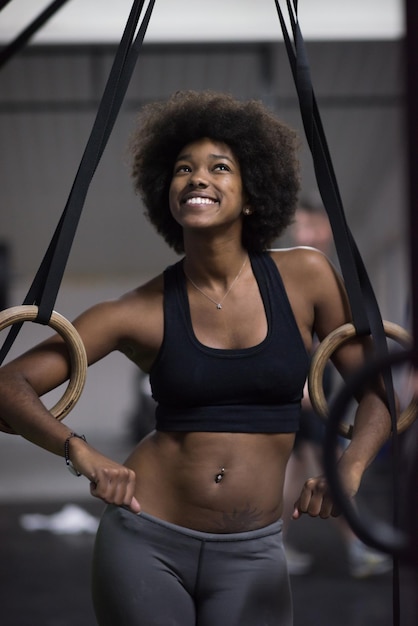 Fitness dip ring african american young woman relaxed after workout at gym dipping exercise