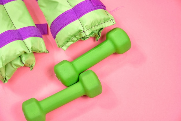 Fitness equipment, green dumbbells and weights.