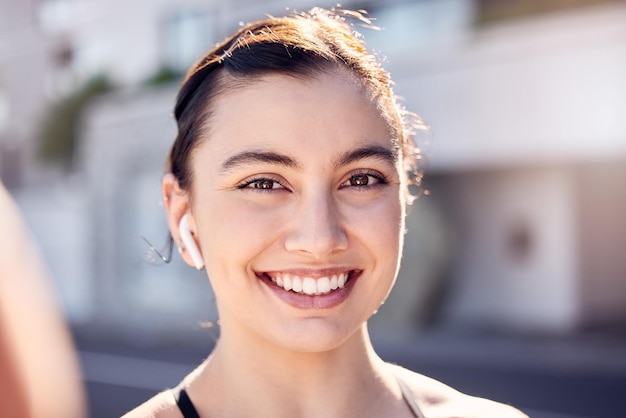 Fitness exercise and selfie with a woman listening to music for running workout and cardio training outdoor in a city Portrait face and smile of female happy for social media inspiration