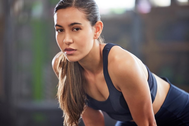 Fitness gym and athletic woman taking a break and resting after a workout Portrait of a fit and healthy woman looking tired after exercising and being active at a health and wellness facility