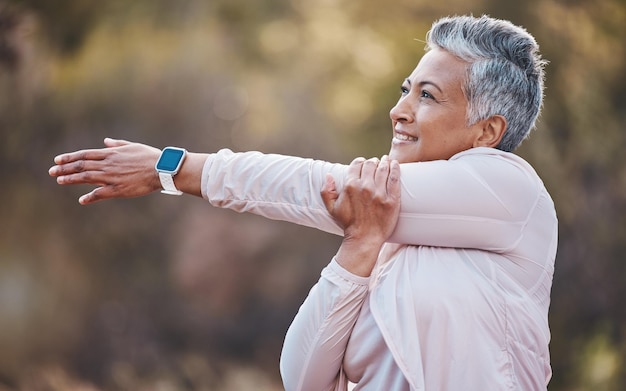 Fitness happy or old woman stretching in nature to start training hiking exercise or workout in Portugal Wellness warm up or healthy senior person smiles thinking of goals vision or motivation