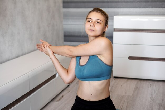 Photo fitness, home and diet concept. smiling girl streching on floor at home