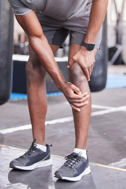 Fitness injury and knee pain of black man at gym with inflammation problem resting legs Joint pain accident and cardio exercise person injured training at health club trauma assessment