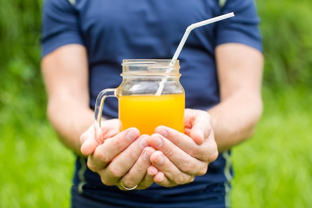 Fitness man holding a glass of orange juice