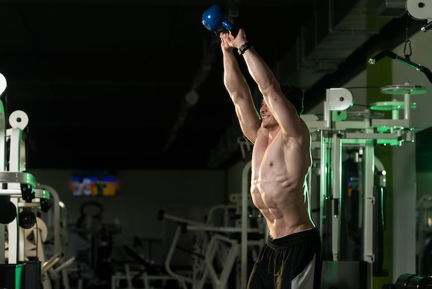 Fitness Man Using Kettlebells Inside Gym