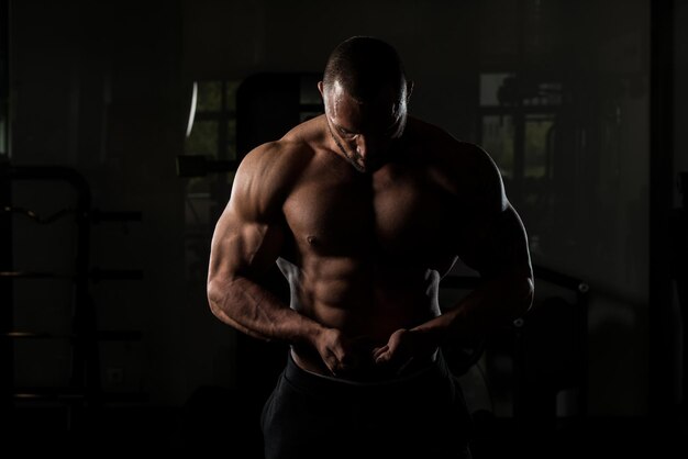 Fitness Shaped Muscle Man Posing In Dark Gym