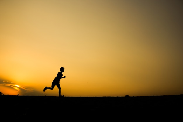 Fitness on silhouette sunrise The boy running workout wellness concept.