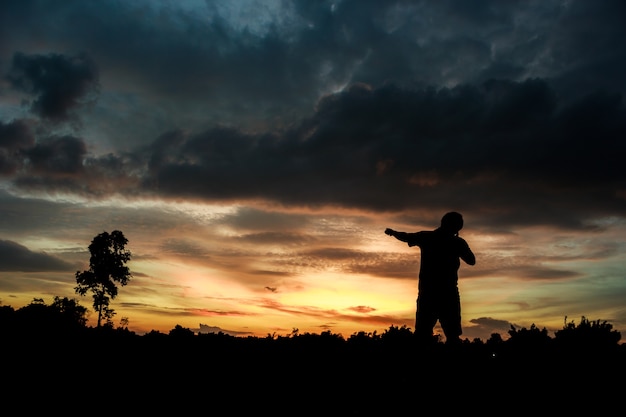 Fitness on silhouette sunrise The boy  workout wellness concept.