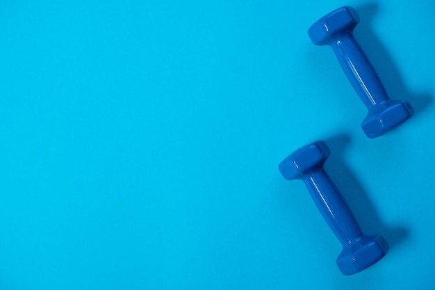 fitness sport concept Blue dumbbells on Blue background