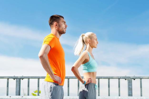 fitness, sport, friendship and healthy lifestyle concept - sporty couple outdoors