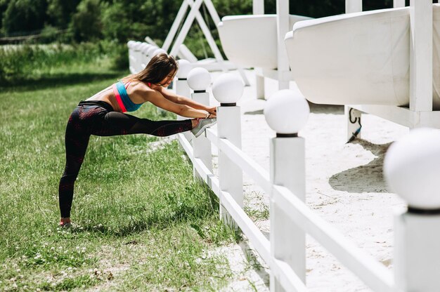 Fitness sport girl in fashion sportswear doing yoga fitness exercise in the park