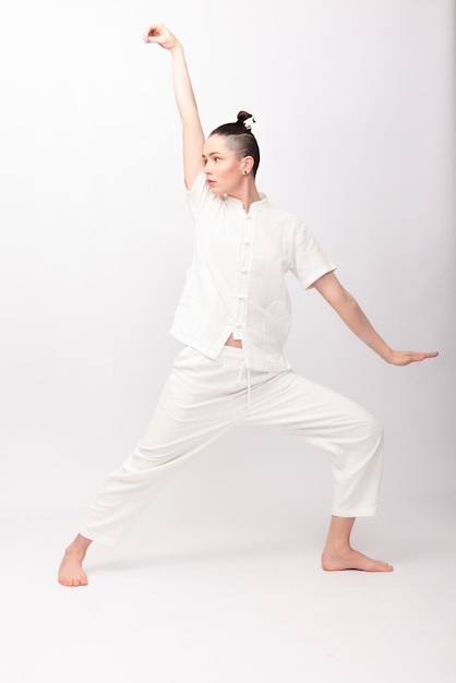 fitness sport training and lifestyle concept Young woman doing yoga exercise Young Woman praticing tai chi chuan in the gym Chinese management skill Qi's energy