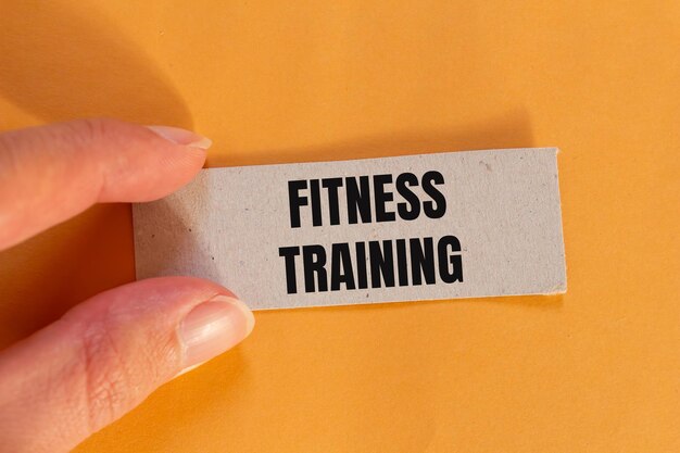 Photo fitness training message written on ripped paper piece with orange background conceptual fitness training symbol copy space