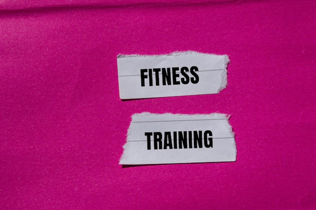 Photo fitness training message written on ripped torn paper pieces with pink background conceptual fitness training symbol copy space