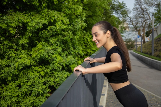 Fitness woman doing sport exercises enjoying outdoor workout in park