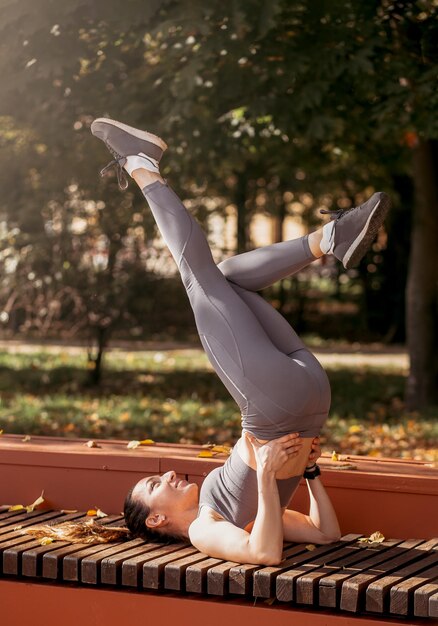 Fitness woman doing yoga exercises stretching in summer park Sport Healthy concept