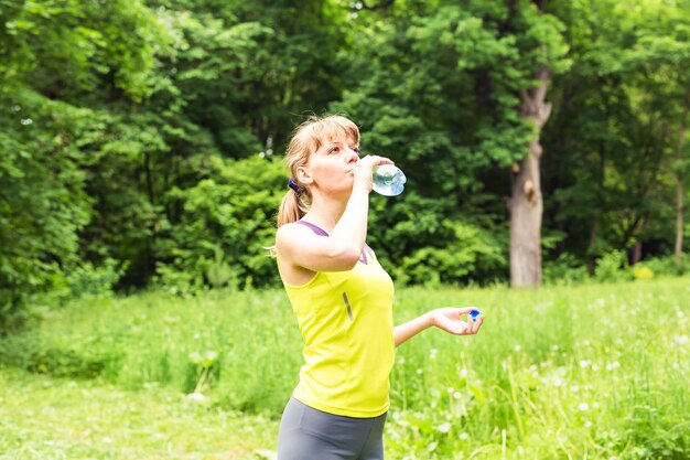 Fitness woman drinking water from bottle.