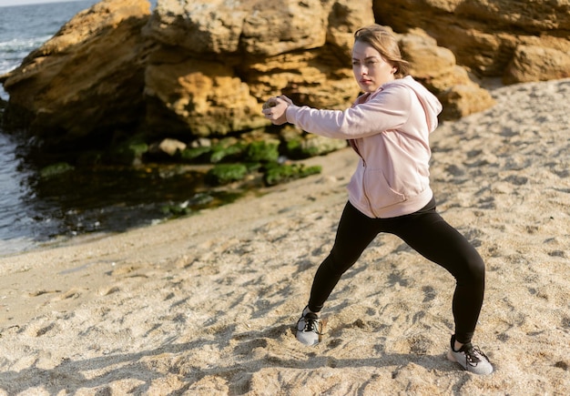 Fitness woman exercising with a stone on a wild beach Healthy lifestyle fitness concept