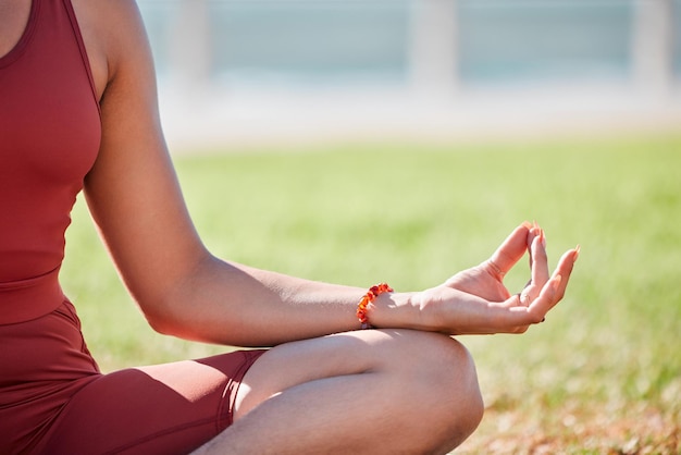 Fitness woman and hands in meditation for yoga spiritual wellness or peaceful exercise in nature Hands of female yogi in calm meditating for zen workout relax or awareness on grass field outdoors