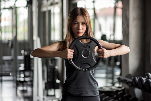 Fitness woman lifting weight in gym