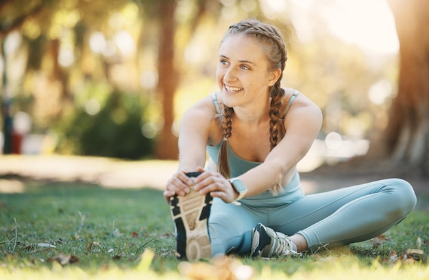 Fitness woman and stretching by woman in a park for yoga wellness and exercise zen and happy in nature Exercise girl and leg stretch before mediation in a forest for cardio workout and pilates