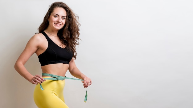 Fitness woman with a measurement tape