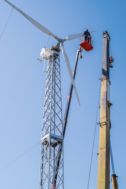 Fitters use truck crane and aerial platform to install wind turbine rotor