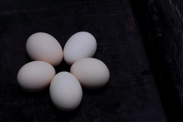 Five eggs in the form of a flower on a dark background Organic healthy food Closeup View from above