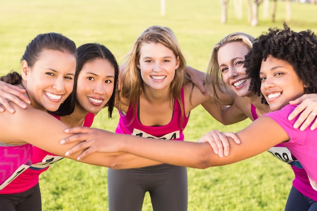 Five smiling runners supporting breast cancer marathon