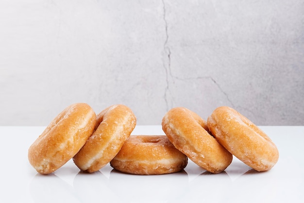 five sugar doughnuts stone color background