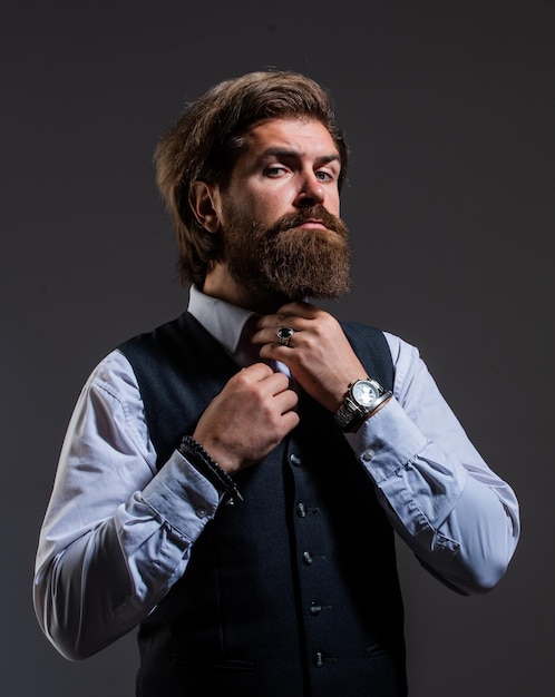 Fixing bow tie stylish successful man in suit posing business man wear suit official office lifestyle serious bearded man handsome successful man in expensive suit He in shirt with hand watch