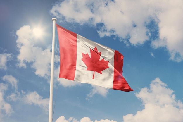 Flag of Canada, National symbol waving against cloudy, blue sky, sunny day