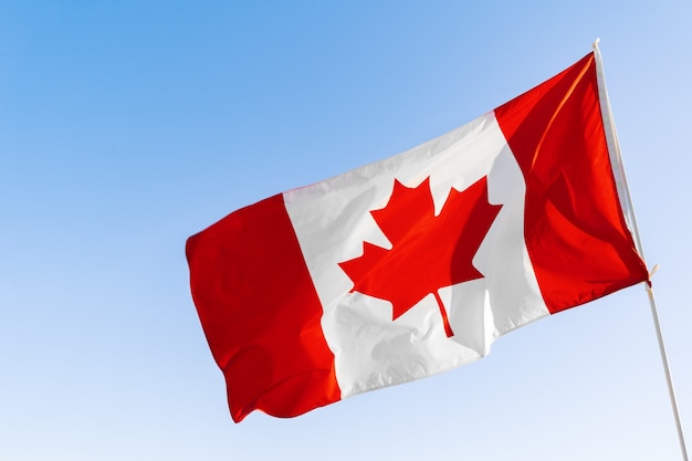 Flag of Canada waving against clear blue sky