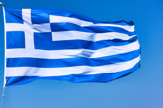 Flag of Greece close-up. Waving national greek flag agaist the blue sky